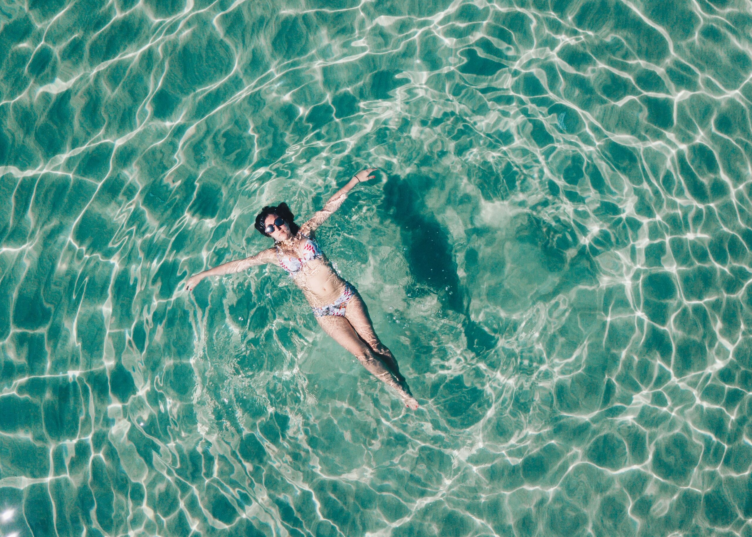Frau in Bikini im Wasser aus Vogelperspektive sinnbildlich für Hautpflege im Intimbereich Deumavan®