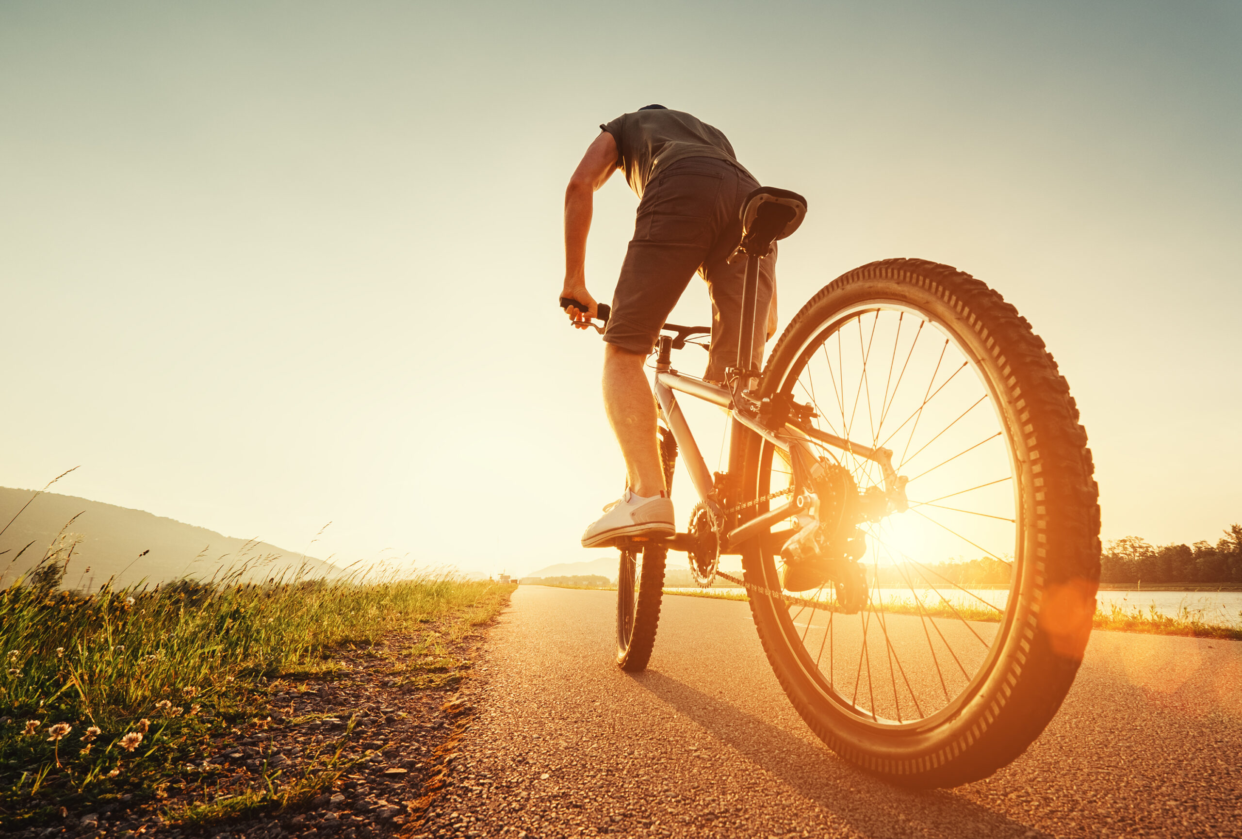 Mann auf Fahrrad vor Sonnenuntergang sinnbildlich für Hautirritationen und Hautreizungen im Intimbereich beim Sport Deumavan®