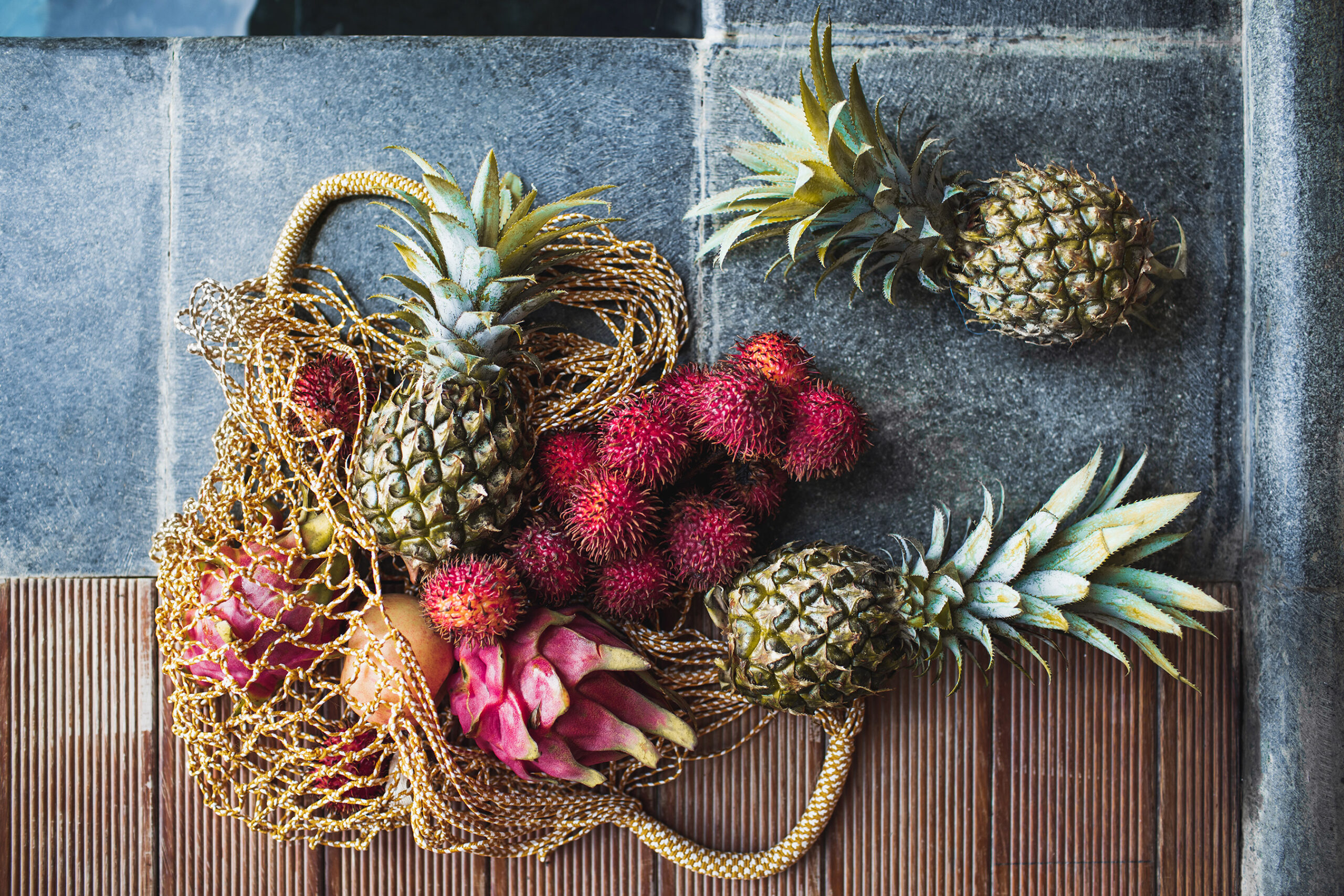 Flechtsack mit stacheligen Früchten wie Ananas und Drachenfrucht sinnbildlich für Juckreiz und Brennen im Intimbereich